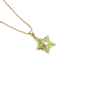 Macro detail of 18k gold plated star pendant with green enamel and square zircon