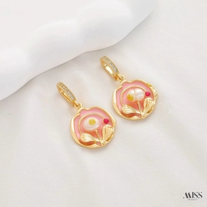 Close-up of pink enamel flower earrings with freshwater pearls and zircon hooks