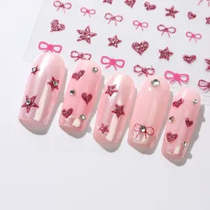 Detail of pink glitter nail stickers with bows and stars applied on pearly nails