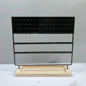 Detail of black 144-hole metal earring organizer with a natural solid wood base