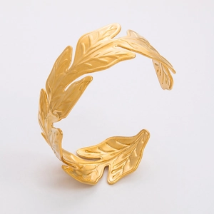 Detailed close-up showing the refined leaf texture on the golden stainless steel bangle