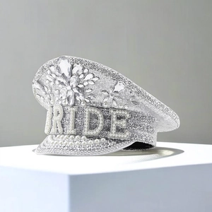 Detailed view of silver sequin bride hat with pearl BRIDE text and rhinestone flower