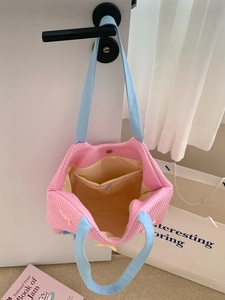 Detail view of the pink and blue woven tote bag with magnetic closure and interior pockets