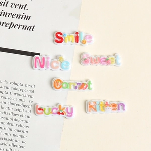 Macro detail of colorful resin DIY charms with Smile and Lucky text designs
