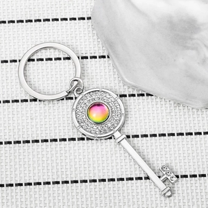Macro view of silver key keychain with embedded diamonds and rainbow gemstone detail