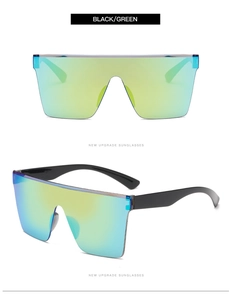 Detail view of large frame sunglasses featuring black frame and green gradient mirror lenses