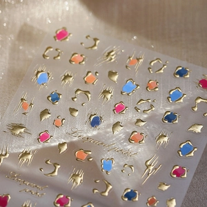 Leopard print nail stickers with gold foil detailing on light gold texture fabric