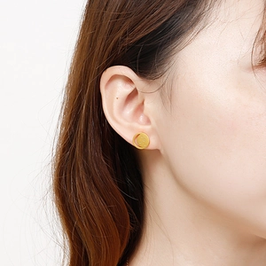 Close-up of golden moon and star stud earrings on model's ear for daily wear