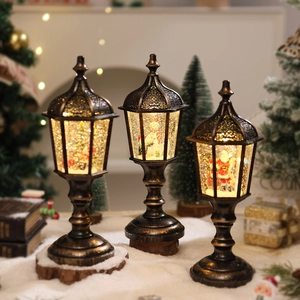 Three vintage glowing Christmas lanterns with Santa scenes and swirling snow effects