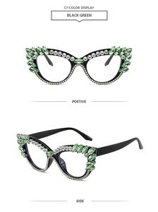 Detail of oversized black cat-eye glasses frame with green rhinestones and white crystals