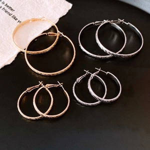 Strukturierte Creolen in Gold und Silber mit mattem Finish auf schwarzem Tablett