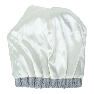 Close-up of white satin sleep bonnet with grey knit elastic band on white background