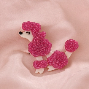Detailed close-up of pink glitter poodle brooch with delicate black eyelashes on pink silk
