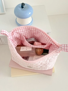 Pink and white checkered quilted makeup bag with interior pockets for cosmetics storage