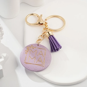 Detail of purple Mother's Day keychain with gold MAMA text and suede tassel