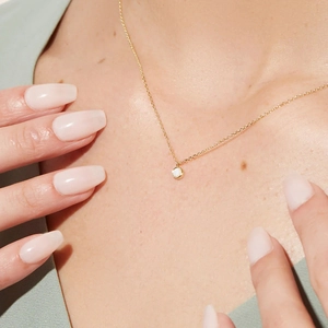 Close-up of elegant S925 silver gold necklace featuring a round opal pendant on the collarbone