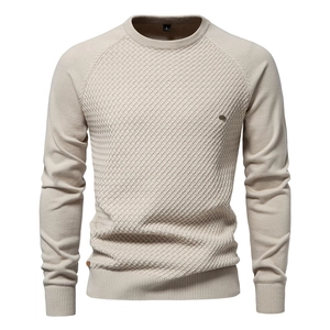 Detailed close-up of beige waffle knit fabric and raglan sleeve stitching on men sweater