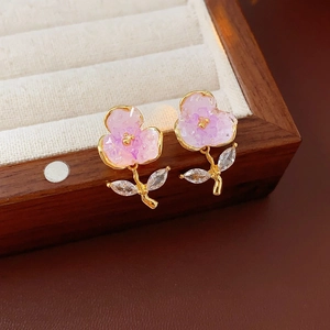 Close-up of pink crystal flower earrings with gold-plated petals and zircon leaf details