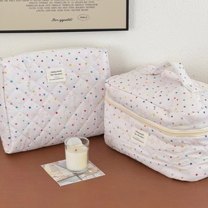 Detailed view of quilted cotton cosmetic bags with pink bow and polka dot patterns