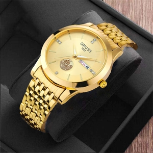 Detail of gold quartz watch dial with sailboat relief and diamond hour markers