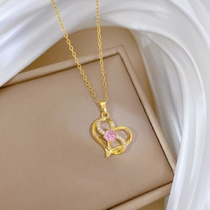 Macro view of gold heart necklace featuring a pink gemstone and shimmering pavé diamonds