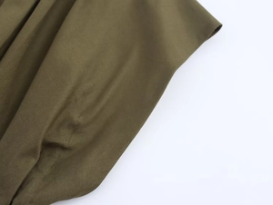 Vue détaillée de la texture du tissu tissé vert olive foncé et de la finition plissée