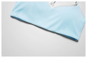 Detail eines hellblauen Sport-BHs mit weißem Rand, glatter Stoff und feine Nähte