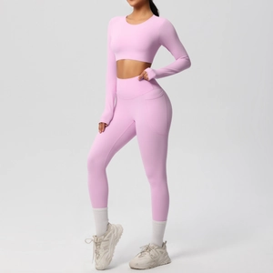 Detail showing side pocket of high-waist pink yoga leggings and long sleeve crop top set