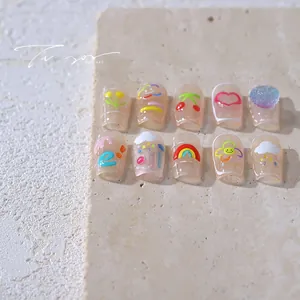 Close-up of 3D nail art stickers with rainbow and cherry patterns on stone plate