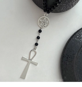 Détail d'un collier gothique en perles noires avec pendentif croix ankh et pentagramme