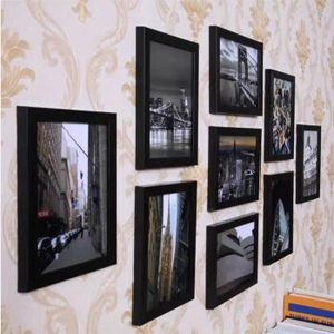Detail of modern minimalist black wall photo frames in a creative layout on a textured wall