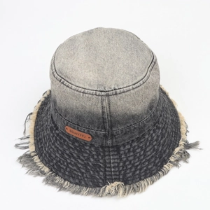 Detail view of denim bucket hat with frayed edges and vintage gradient wash