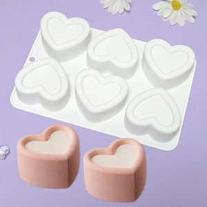 Detail of 6-cavity heart silicone mold with finished pink heart-shaped mousse cakes