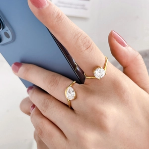Close-up of gold plated adjustable rings with pear and round shaped zircon stones