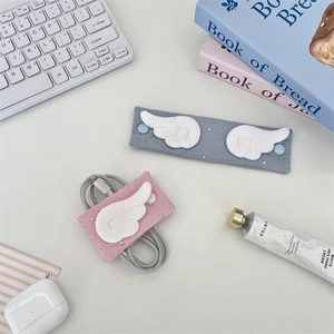 Fabric cable organizers with plush wings and star patterns for travel cord management
