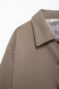 Detail of wool coat lapel with amber buttons and smooth light purple satin lining