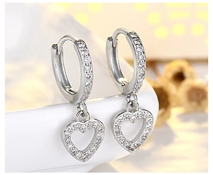 Macro view of elegant pavé heart hoop earrings crafted in s925 sterling silver for women