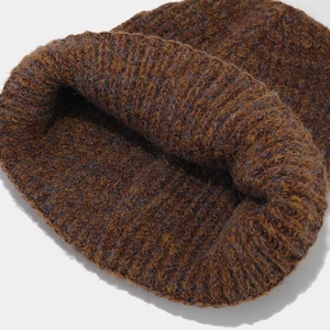 Close-up of thick knitted beanie showing brown mixed-color yarn texture and weave
