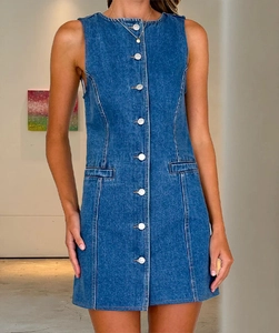 Dettaglio dell'abito corto in denim aderente con bottoni frontali e smanicato
