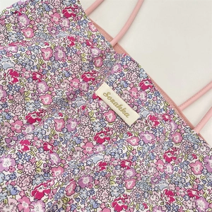 Gros plan sur tissu en toile florale avec bretelles roses et étiquette de marque tissée