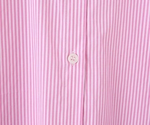 Dettaglio del tessuto a righe verticali rosa e bianche con un bottone rotondo