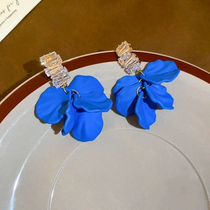Detailed macro view of royal blue petal earrings with crystal zircons and gold setting