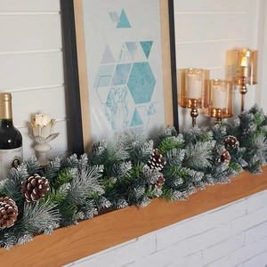 Lush snow-flocked Christmas garland with pine cones on fireplace mantel decor
