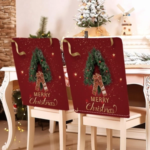 Detail view of red linen Christmas chair covers with festive wreaths and gold lettering