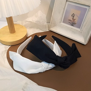 Close-up of elegant double-layer bow headbands in black and white fabric styles