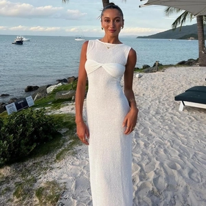 Gros plan détaillé d'une robe en tricot sans manches blanche avec nœud torsadé sur la plage