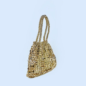 Detailed view of handmade gold metallic woven handbag featuring shiny circular sequins