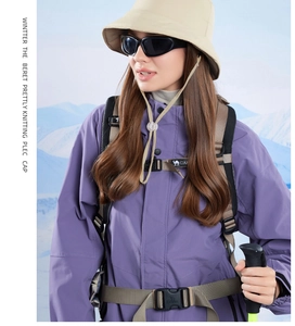 Detail of purple windproof jacket, khaki bucket hat, and professional hiking backpack