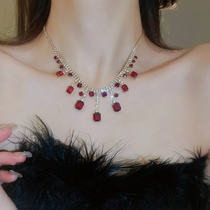Close-up of elegant red gemstone necklace with silver rhinestones on a female model
