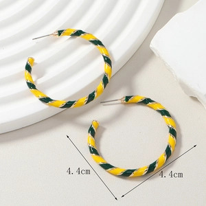 Detail shot of large 4.4cm hoop earrings with yellow and dark green striped patterns